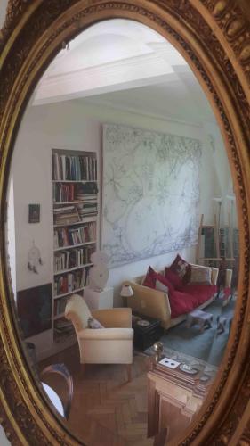 Un reflejo de una sala de estar con un sofá en un espejo. en Appartement château classé, site remarquable, 1chbre, en Salbris