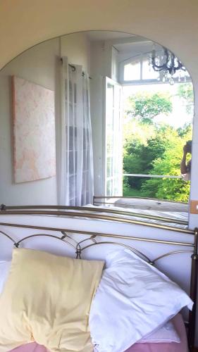 - un lit avec un oreiller en face d'une fenêtre dans l'établissement Appartement château classé, site remarquable, 1chbre, à Salbris