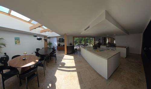 a kitchen and living room with a table and chairs at Villa Namasté SPA Hammam port & Mer in La Trinité-sur-Mer