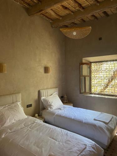 a bedroom with two beds and a window at Ranch Skouraya in Tajante
