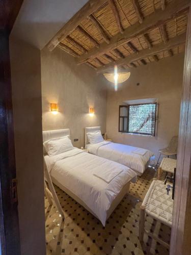 a bedroom with two beds and a window at Ranch Skouraya in Tajante