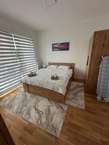 a bedroom with a bed and a large window at ZORA apartmani Sarajevo in Sarajevo
