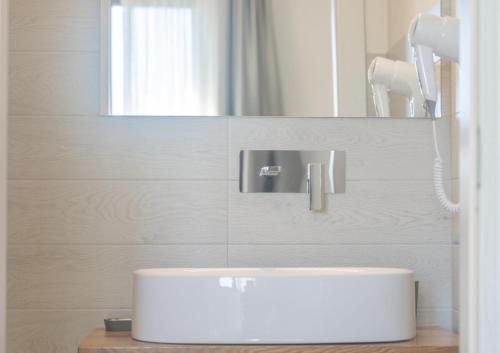 a bathroom with a white sink and a mirror at Calafato Guest House in Favignana