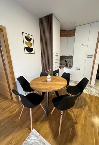 a dining room with a wooden table and chairs at ZORA apartmani Sarajevo in Sarajevo