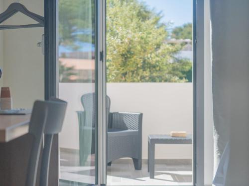 a room with a glass door with a chair and a table at Calafato Guest House in Favignana