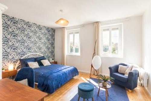 une chambre avec un lit bleu et une chaise bleue dans l'établissement Séjour familial haut de gamme spa et confort près des plages du Débarquement, à Sommervieu