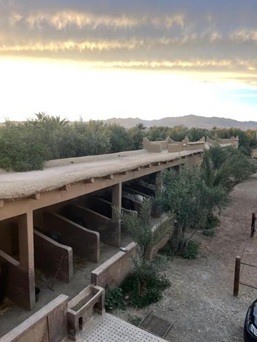 a building with a long bridge in the desert at Ranch Skouraya in Tajante