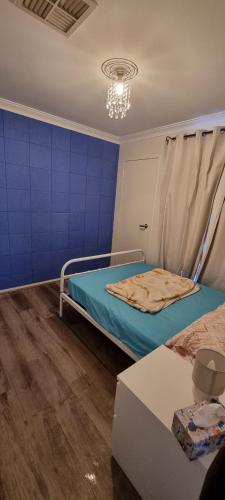 a room with two beds and a blue wall at check in 11am check out 2pm in Riverton in Perth