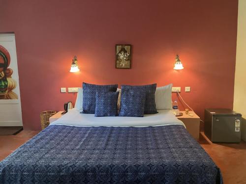 a bedroom with a large bed with blue pillows at Marari Dreamz Homestay in Mararikulam