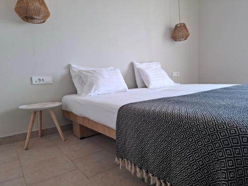 a bed with white pillows and a table in a room at Hotel Platon in Faliraki