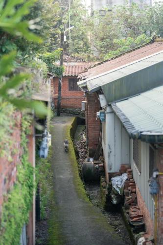 a narrow alley between two brick buildings and a building at OR Inn Beipu in Beipu