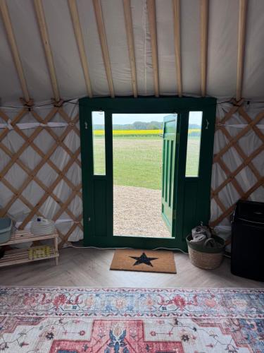 an open door to a yurt with a rug in a room at The Skye Yurt in Messing