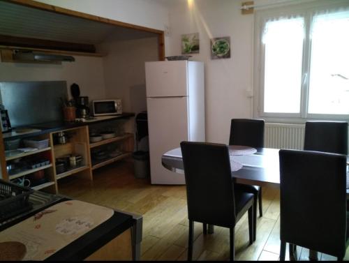 une cuisine avec une table et un réfrigérateur blanc dans l'établissement Vue sur les montagnes, à Grignon