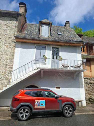 a red car parked in front of a house at La belle vie in Vieillevie