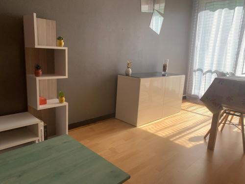 - un salon avec une armoire blanche et une table dans l'établissement Entire F2 apartment feveretere, à Chalon-sur-Saône