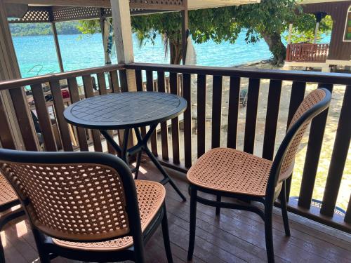 a table and chairs on a balcony with the water at Mama's Chalet Pulau Perhentian Besar in Perhentian Island