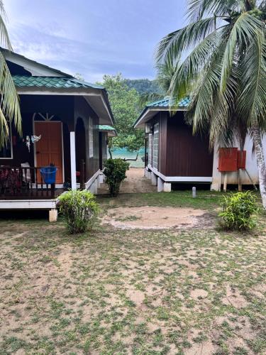 a house with a palm tree in front of it at Mama's Chalet Pulau Perhentian Besar in Perhentian Island