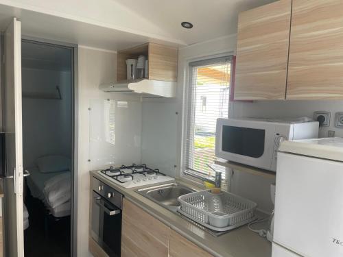 a small kitchen with a sink and a microwave at Mobilhome in Litteau
