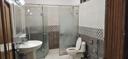 a bathroom with a shower and a toilet and a sink at Butt Lodges 2 in Islamabad
