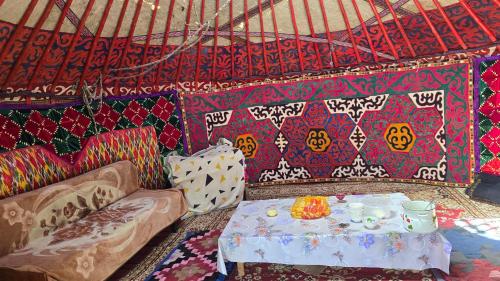 a room with a couch and a table in a room at "Doskulu travel" hostel in Kyzart