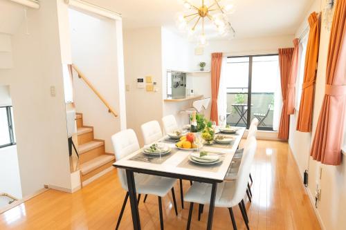 a dining room with a table and white chairs at 4 卧室 - 3 浴室 - 3 卫生间 - 100 平方 新装 别墅 - 新宿 4 分钟 - Sakura House in Tokyo