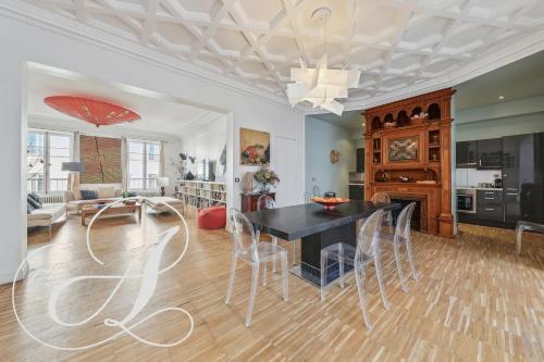 une salle à manger et un salon avec une table et des chaises dans l'établissement Philosophy, luxury apartment for 6 in Madeleine, à Paris