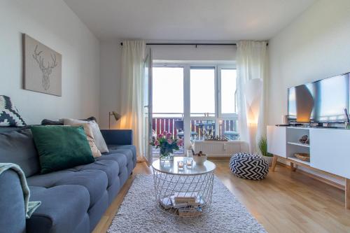 a living room with a blue couch and a tv at Apartment Bergliebe I Balkon I Aufzug I Stellplatz in Schwarzenberg