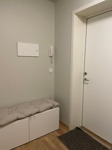 a white room with a bed and a door at Central apt near beach and city life in Kristiansand