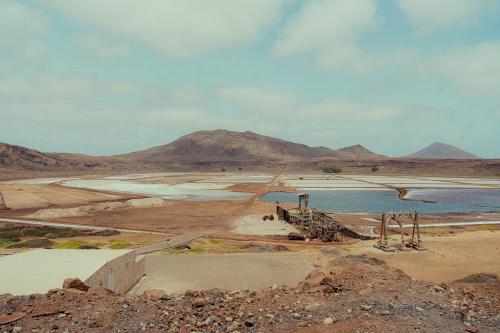 a desert with a body of water and mountains at Branco Suites - Rooms & Holiday Apartments in Santa Maria