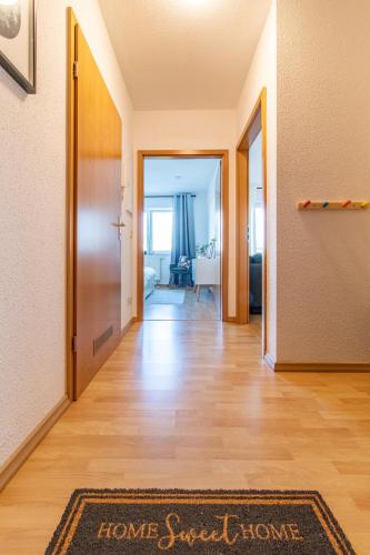 a hallway with a home sweet home rug on a hard wood floor at Apartment Bergliebe I Balkon I Aufzug I Stellplatz in Schwarzenberg