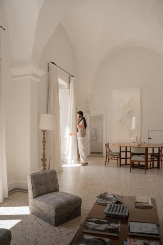 a woman standing in front of a window in a living room at Palazzo Maritati in Nardò