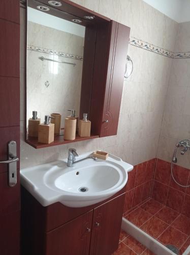 a bathroom with a sink and a mirror at Tassos Holiday home in Archangelos