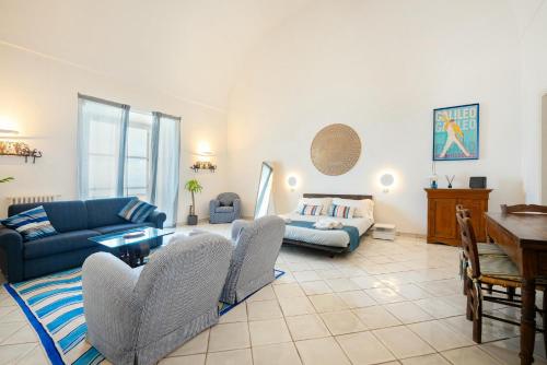 a living room with a blue couch and a table at Suite Palazzo Capri - Seaview in Capri