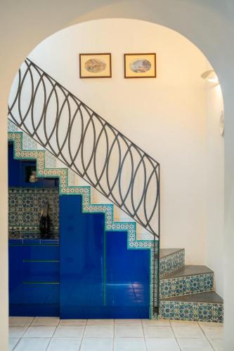 a staircase in a room with a blue wall at Suite Palazzo Capri - Seaview in Capri