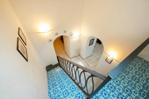 a staircase in a building with a blue carpet at Suite Palazzo Capri - Seaview in Capri