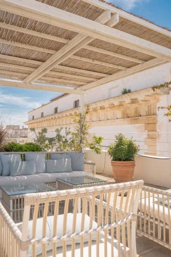 a patio with a wooden pergola and a table at Palazzo Maritati in Nardò