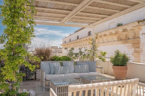 a patio with a couch and tables on a balcony at Palazzo Maritati in Nardò