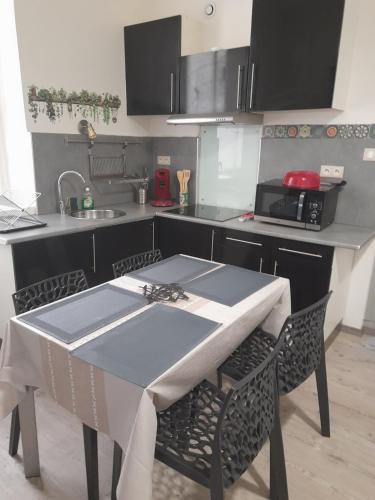 - une cuisine avec une table et un évier dans l'établissement Escale Voltaire T2 au calme, CV, WIFI, à Narbonne