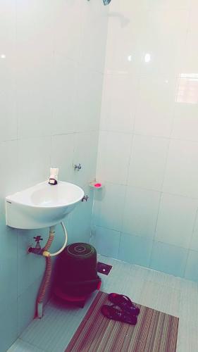 a bathroom with a white sink and a rug at vishranti bhawan in Dwarka