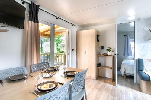 un comedor con mesa y sillas y una habitación en Luma Lodge, en Seignosse