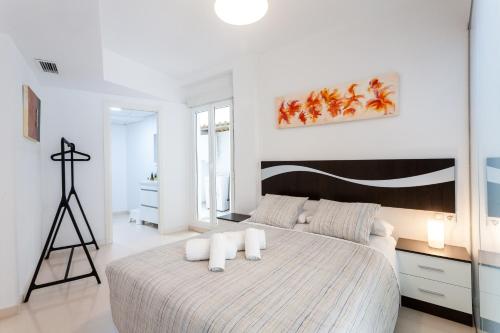 a white bedroom with a large bed with two pillows at My Loft 4 You Na Jordana in Valencia