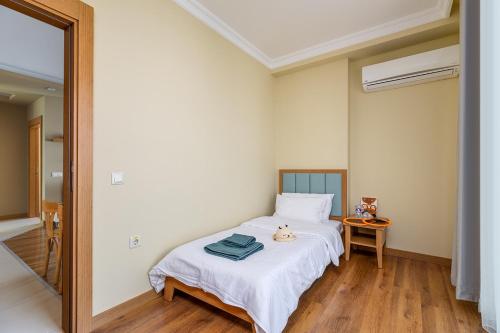 a bedroom with a bed with white sheets and a table at The Suites in Antalya