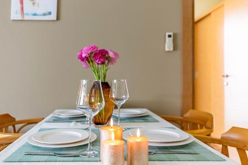 a table with plates and glasses and a vase with flowers at The Suites in Antalya