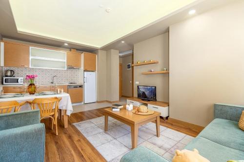 a kitchen and a living room with a table and a couch at The Suites in Antalya
