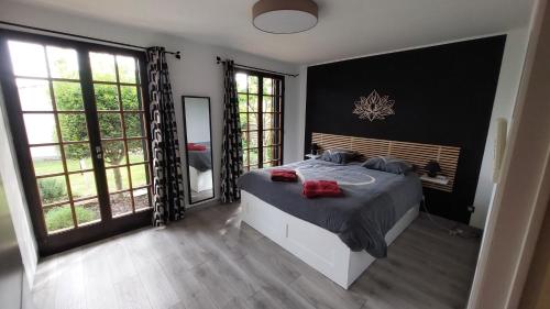 une chambre avec un grand lit et de grandes fenêtres dans l'établissement Les Pieds dans Thau, à Marseillan