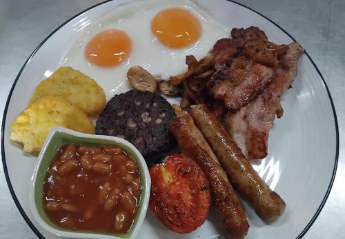 a plate of breakfast food with eggs sausage and meat at Water's Edge Resort , in Panwa Beach