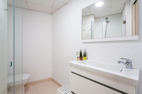 uma casa de banho branca com um lavatório e um WC em My Loft 4 You Na Jordana em Valência