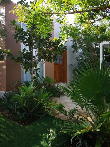 a front door of a house with trees and plants at Little Garden private pool villa in Al Ḩamrāʼ