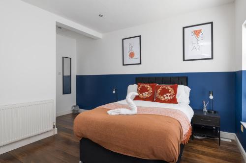 a bedroom with a bed with a swan on it at Spacious & Charming 2BR - Perfect Stay in Northampton
