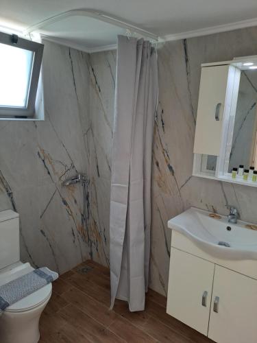 a bathroom with a shower curtain and a sink at Almyra Apartments & Suites in Sfakaki